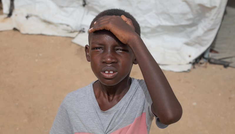 Ali zasłania dłonią twarz przed słońcem