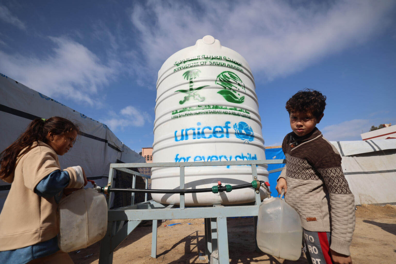 Dzieci przychodzą po wodę do zbiornika przywiezionego przez UNICEF.