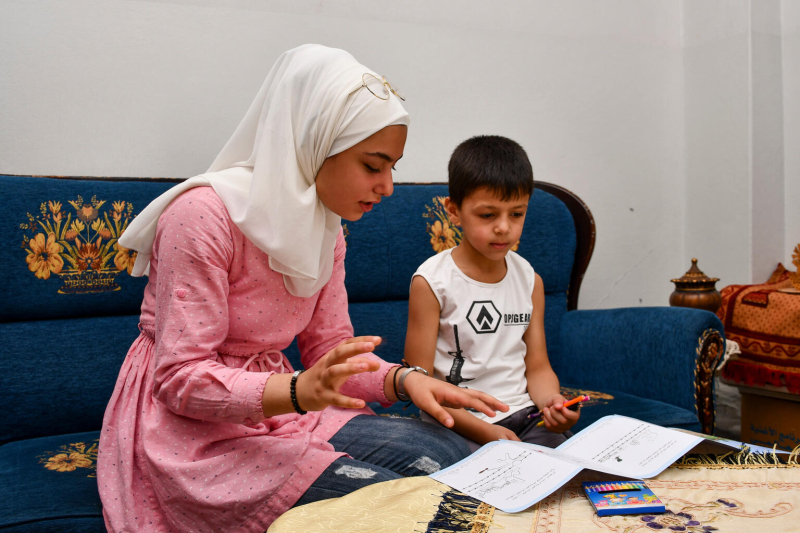Dziewczynka z Syrii tłumaczy chłopcu zadanie