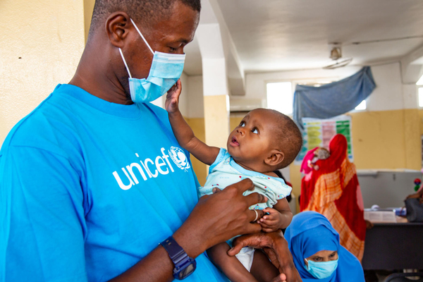 Dziecko na rękach pracownika UNICEF