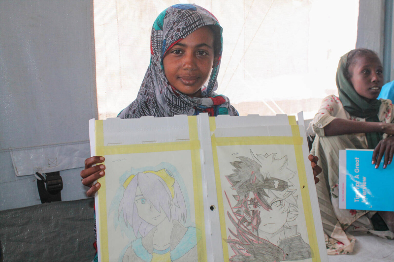 Salawa pozuje ze swoimi rysunkami