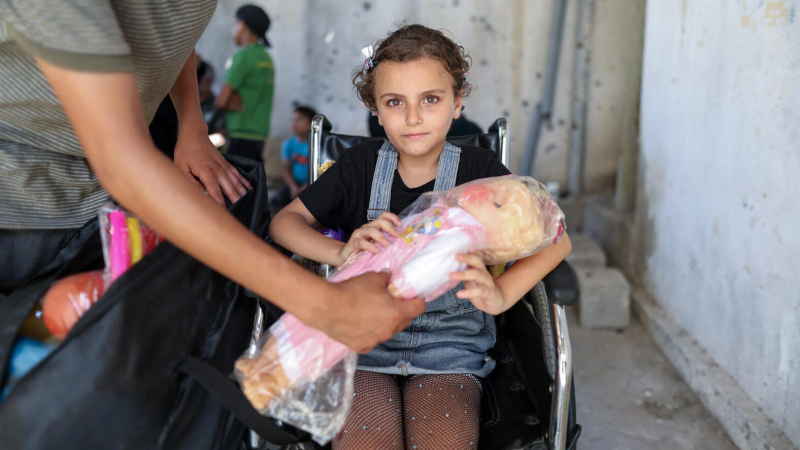 Dziewczynka z lalką na wózku inwalidzkim