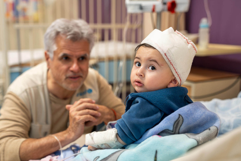 10-miesięczny Ahmad, który odniósł obrażenia podczas izraelskiego nalotu, patrzy w obiektyw aparatu. Chłopiec przebywa w szpitalu w Bejrucie.