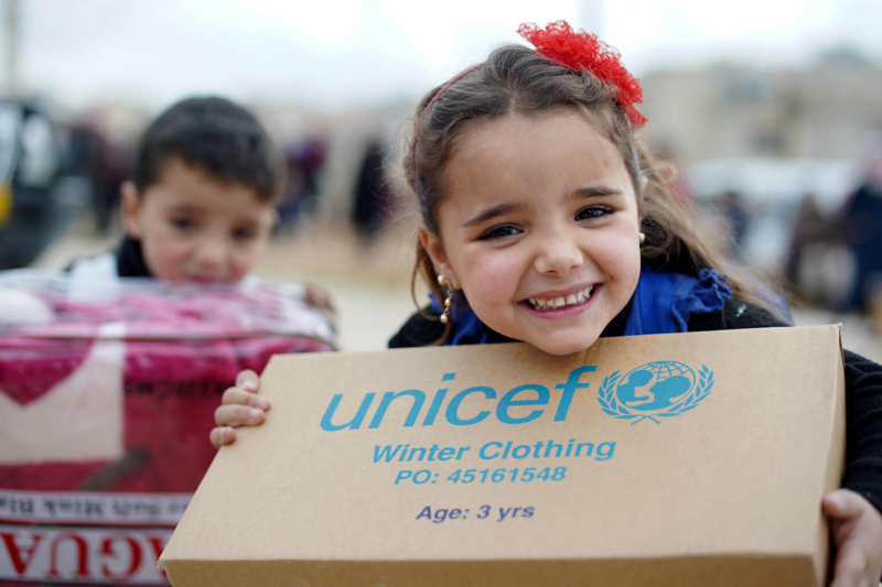 Dziewczynka cieszy się z paczki od UNICEF