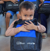 Dziecko przytulające plecak UNICEF.
